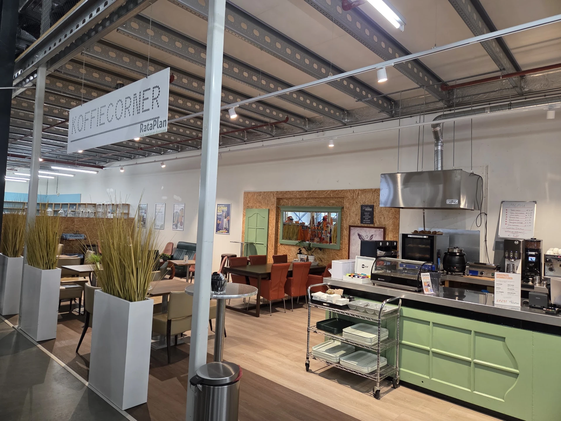 Winkelvloer met groene keukenkasten, huismeubilair, decoratiestukken en diverse gebruiksartikelen in kringloopwinkel.