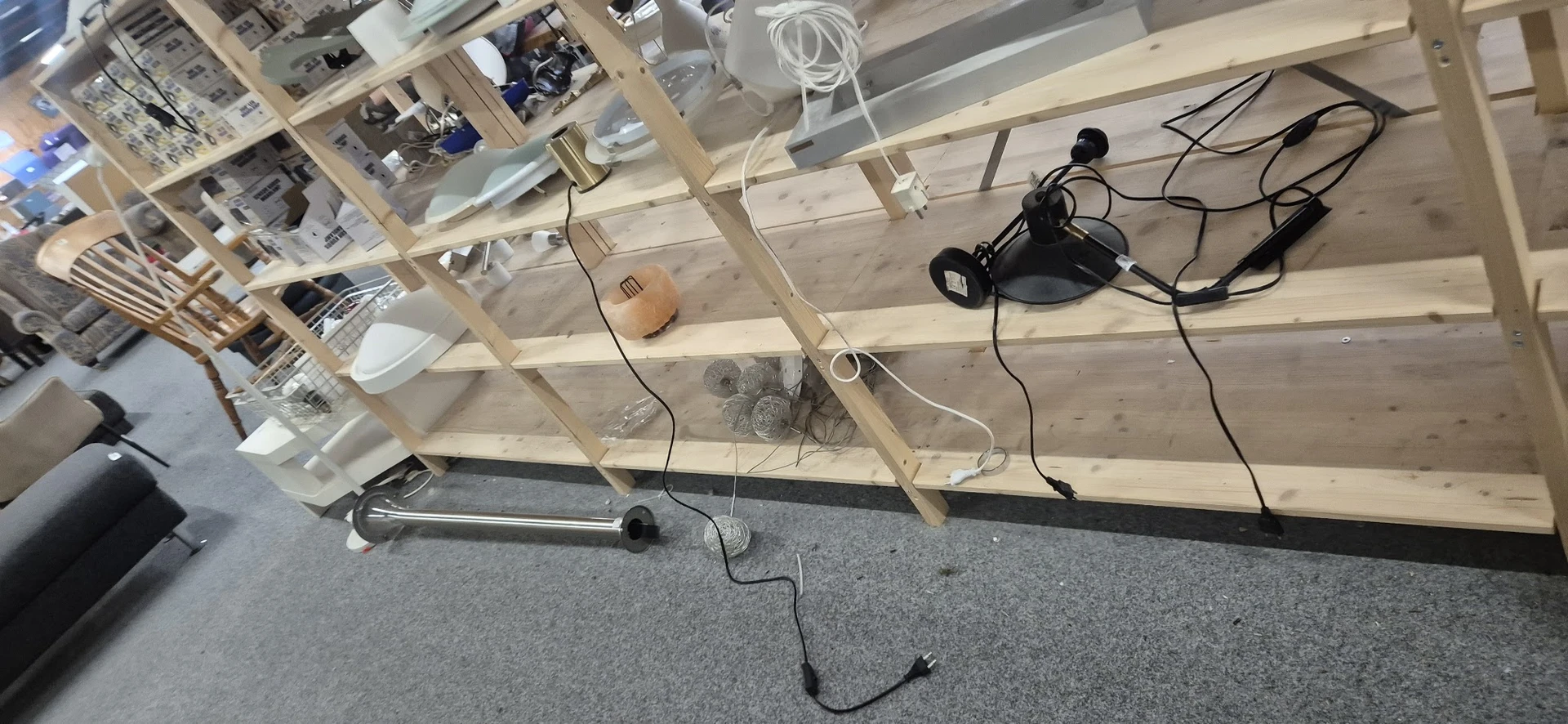 Werkruimte met houten stellingkast, elektrische apparaten en kabels op betonvloer