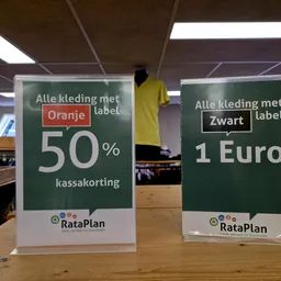 Twee promotieborden met aanbiedingen van kleding met Oranje en Zwart label