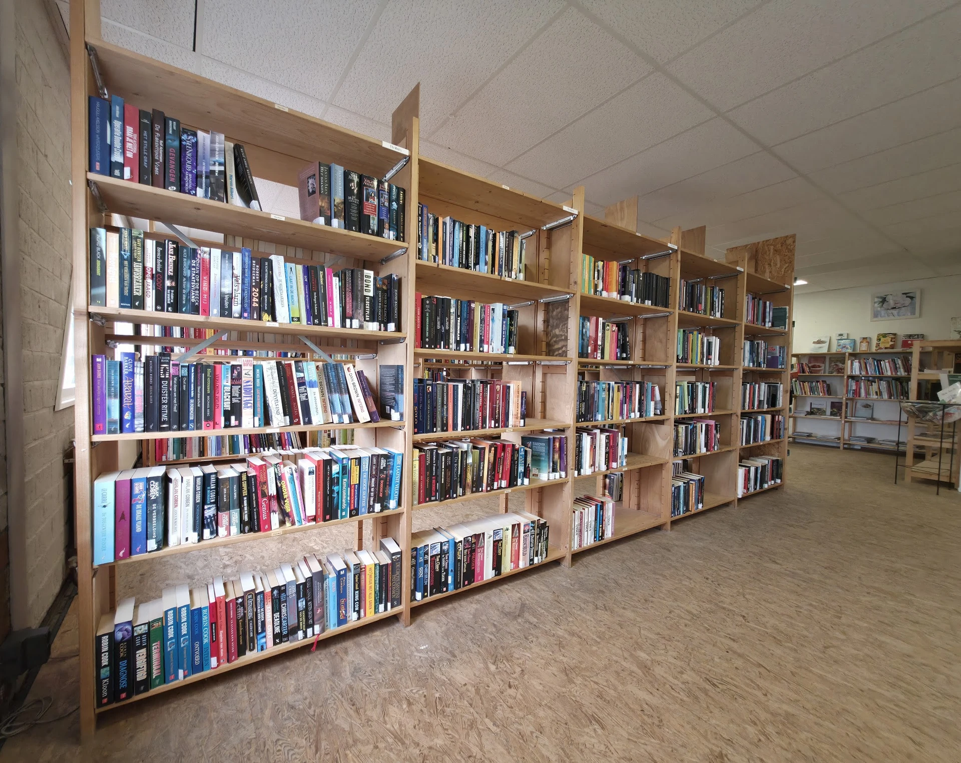 Houten boekenkasten met boeken in een kringloopwinkel