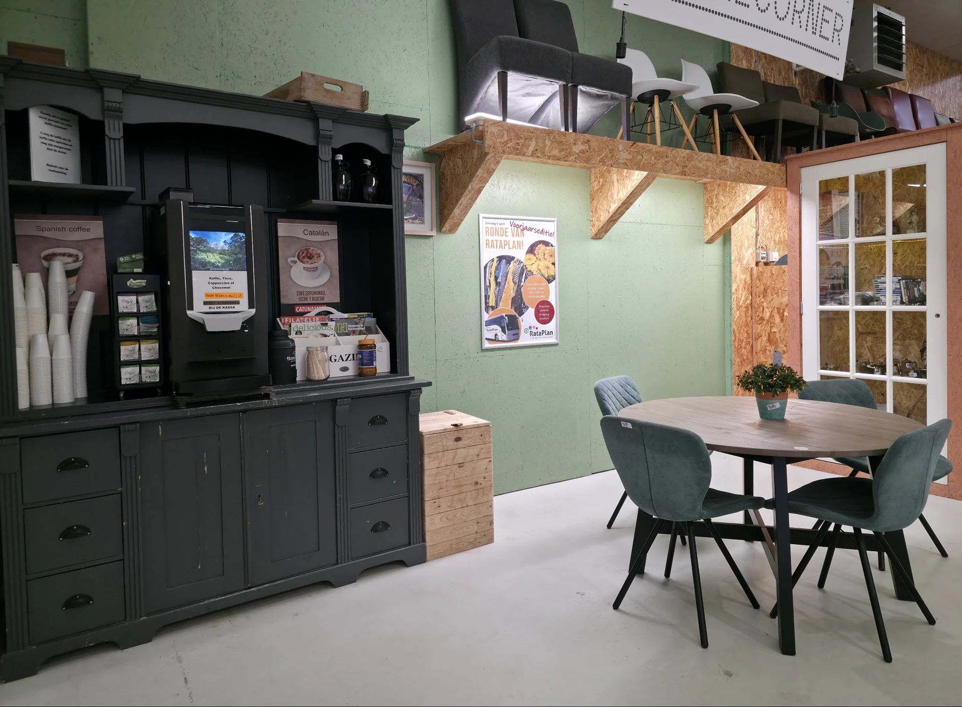 Ingerichte ruimte met zwarte buffetkast, eettafel met stoelen en groene muur met houten details