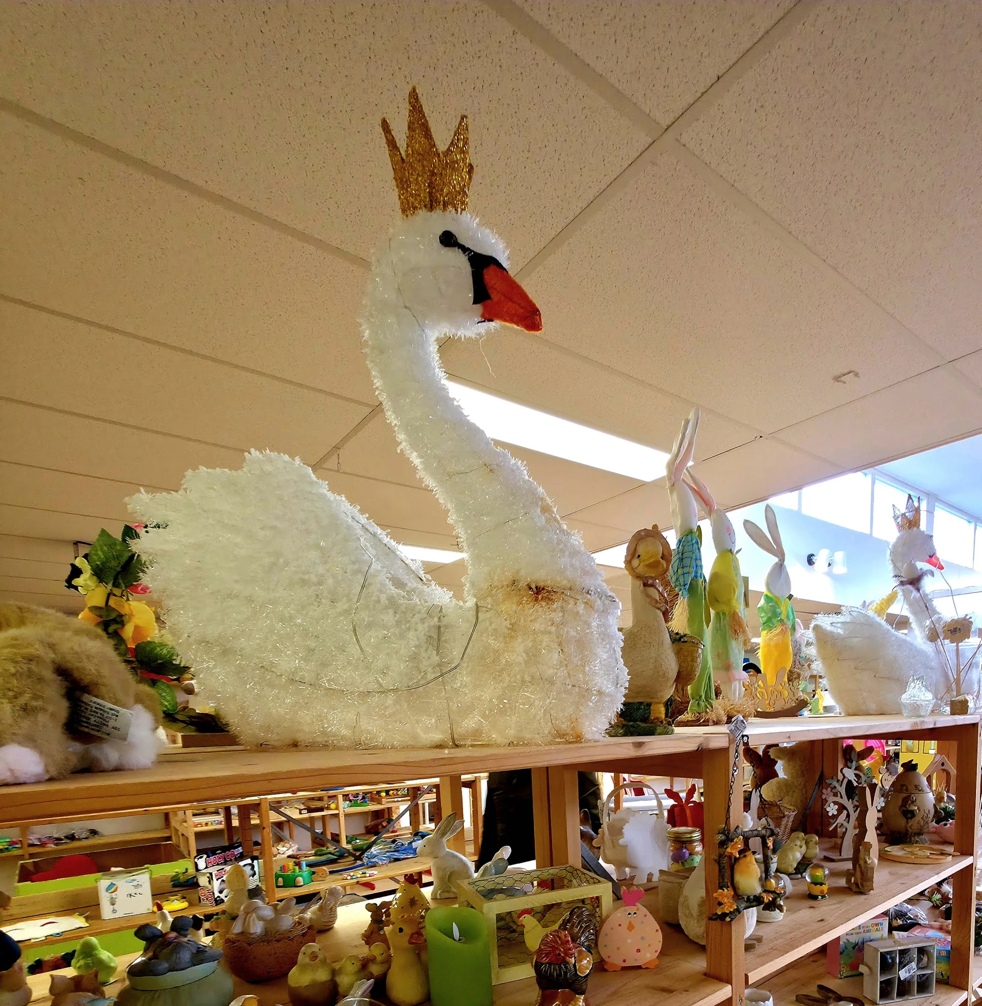 Grote decoratieve witte zwaan met gouden kroon op display in de winkel