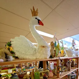 Grote decoratieve witte zwaan met gouden kroon op display in de winkel