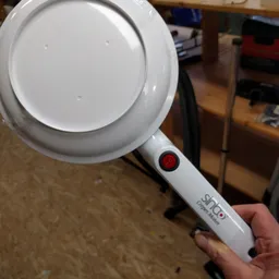 Close-up van een witte handheld-vergrootglas met rode aan/uit-knop