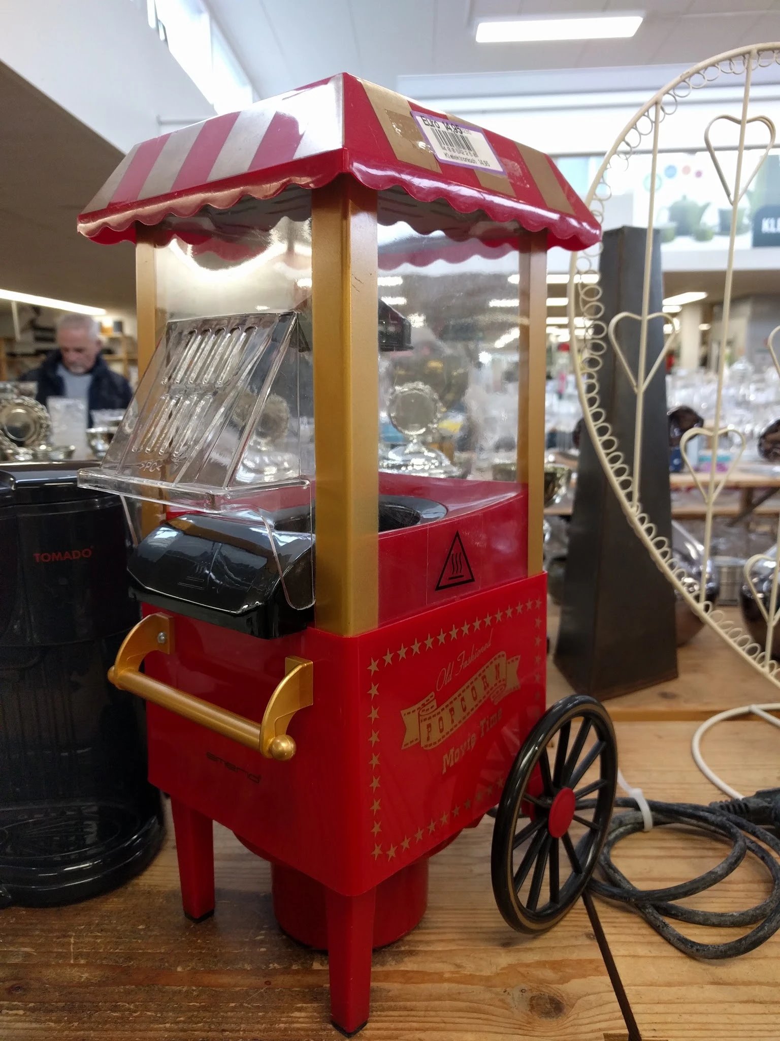Rode vintage popcornmachine met gele details en decoratieve sterren op de voorkant