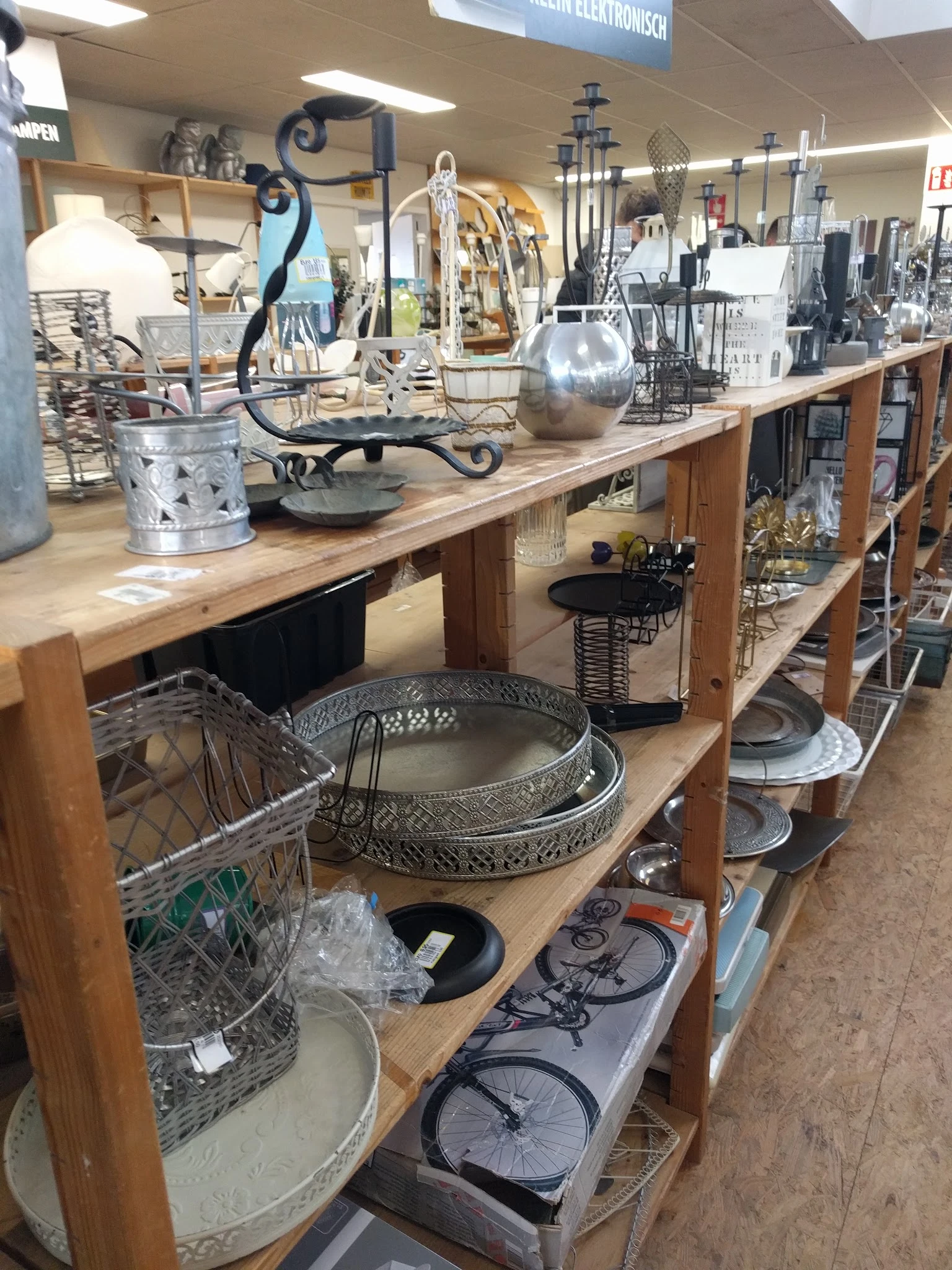 Houten werkbank met diverse huishoudelijke artikelen: decoratieve schalen, manden, en andere gebruiksvoorwerpen.