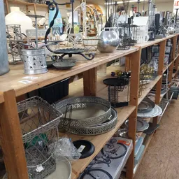 Houten werkbank met diverse huishoudelijke artikelen: decoratieve schalen, manden, en andere gebruiksvoorwerpen.