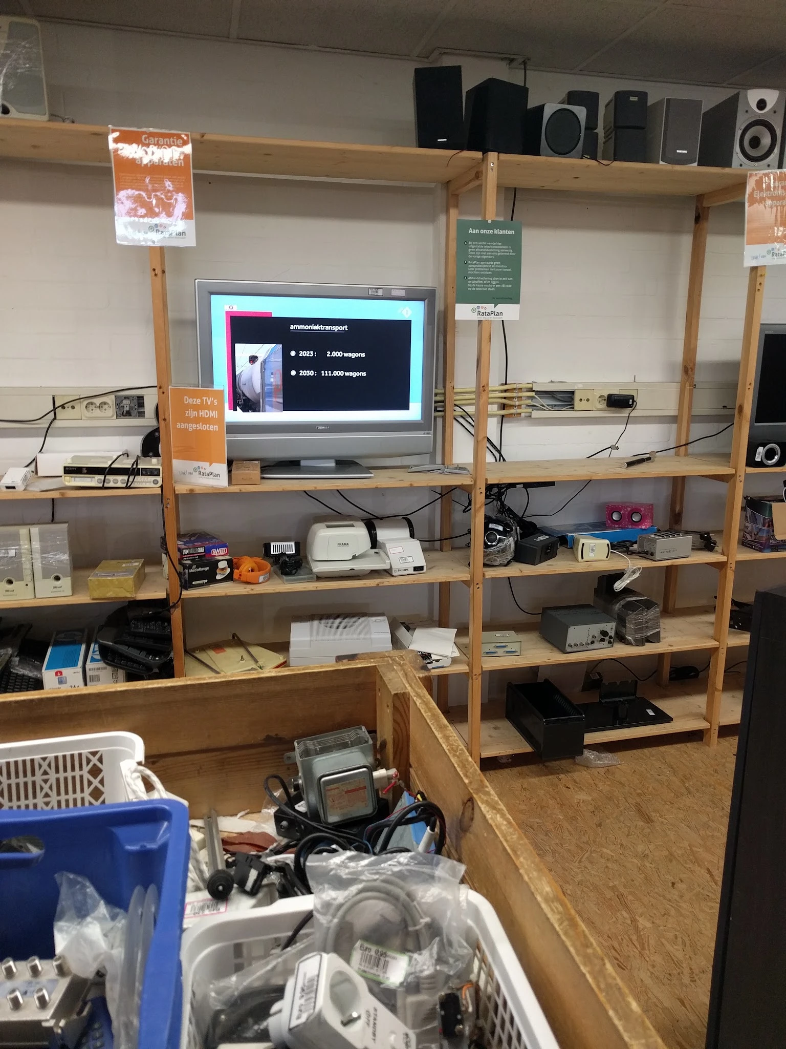 Houten stellingkast met elektronica en apparaten, monitor toont presentatie op scherm