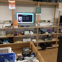 Houten stellingkast met elektronica en apparaten, monitor toont presentatie op scherm