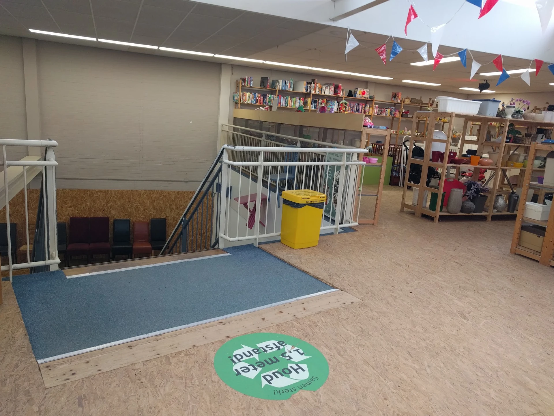 Winkelvloer met speeltoestellen, boekenkast, decoratie en een groene cirkel op de vloer