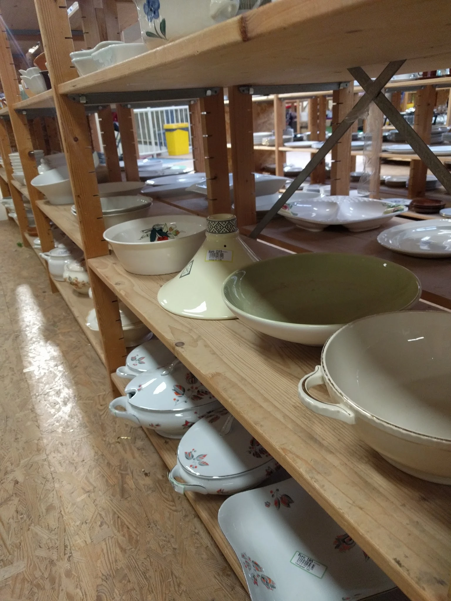 Verschillende serviesgoederen en pannen op houten schappen in de winkel