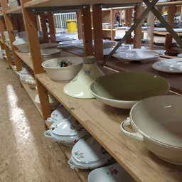 Verschillende serviesgoederen en pannen op houten schappen in de winkel