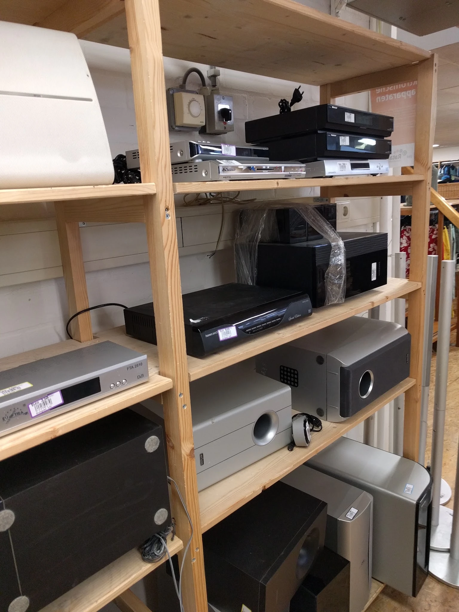 Houten stellingkast met elektronische apparaten zoals dvd-spelers, versterkers en andere audio-visuele apparatuur