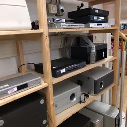 Houten stellingkast met elektronische apparaten zoals dvd-spelers, versterkers en andere audio-visuele apparatuur