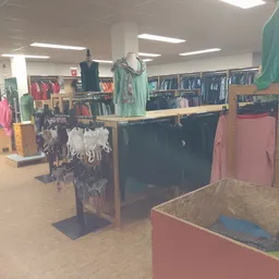 Winkelinterieur met kledingrekken, uitstalkast en mannequins met kleding