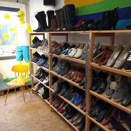 Houten stellingen vol met schoenen en laarzen in verschillende kleuren en stijlen