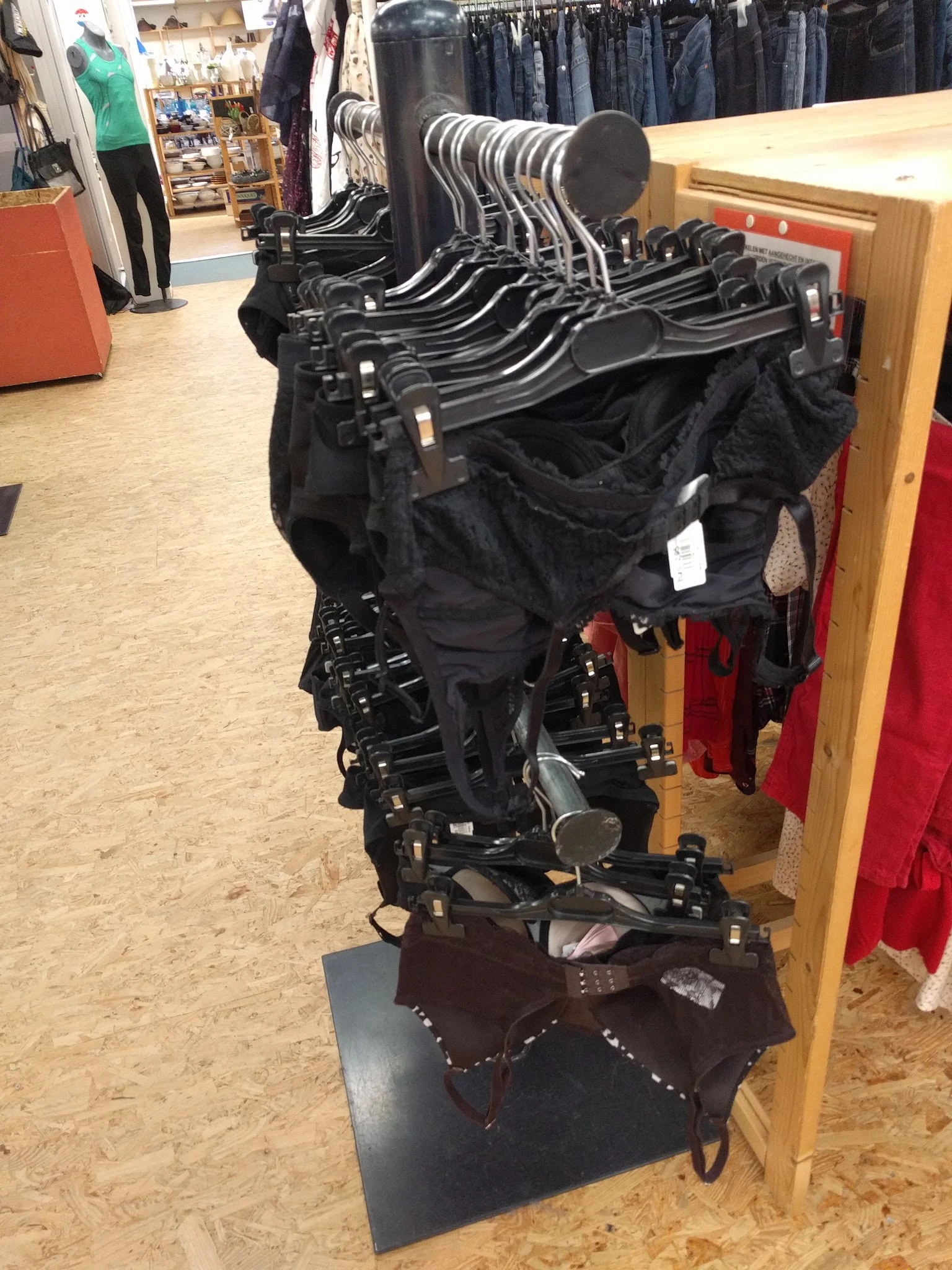Zwarte kinderwagens en buggy's hangen aan een stellage in de winkel