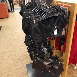 Zwarte kinderwagens en buggy's hangen aan een stellage in de winkel