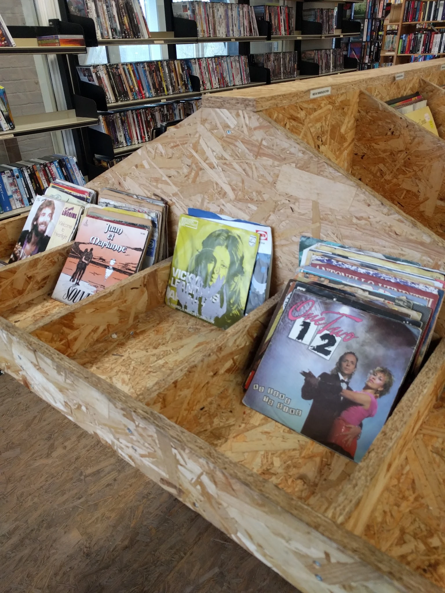 Drie houten bakken met tweedehands dvd's en blu-rays uitgestald in de winkel