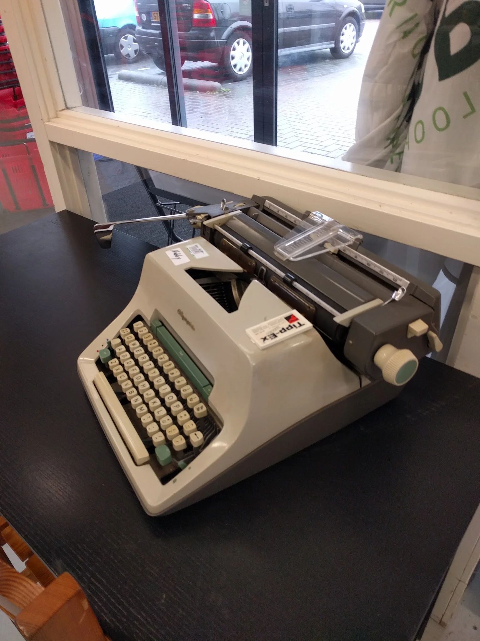 Vintage typemachine met crèmekleurig toetsenbord en zwarte walsen op donkere tafel