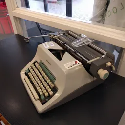 Vintage typemachine met crèmekleurig toetsenbord en zwarte walsen op donkere tafel