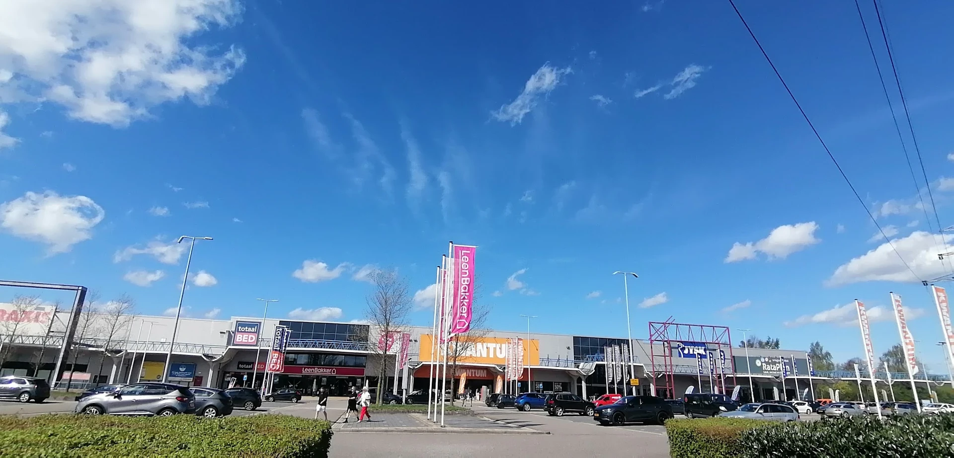 Voorgevel van winkelcentrum met meerdere winkels aan Essenstraat, helder zicht op winkeluitingen