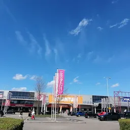 Voorgevel van winkelcentrum met meerdere winkels aan Essenstraat, helder zicht op winkeluitingen