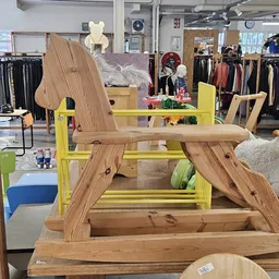Houten meubels en decoratieve items uitgestald in de winkel, waaronder houten stoelen en speelgoed