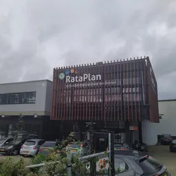 Voorgevel van kringloopwinkel RataPlan met rood-bruine gesloten latten gevel en winkelnaam duidelijk zichtbaar