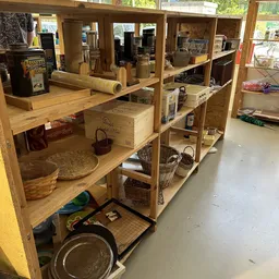 Houten stellingkasten met diverse huishoudelijke artikelen en spullen in een kringloopwinkel