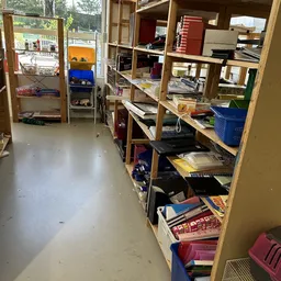 Winkelinterieur met houten stellingen vol boeken, dozen en diverse spullen