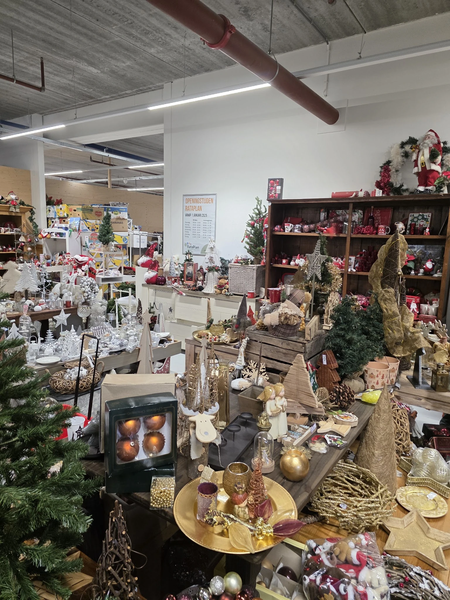 Kerstversiering en decoraties in kringloopwinkel met kasten, stellingen en diverse uitgestalde artikelen