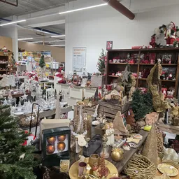 Kerstversiering en decoraties in kringloopwinkel met kasten, stellingen en diverse uitgestalde artikelen
