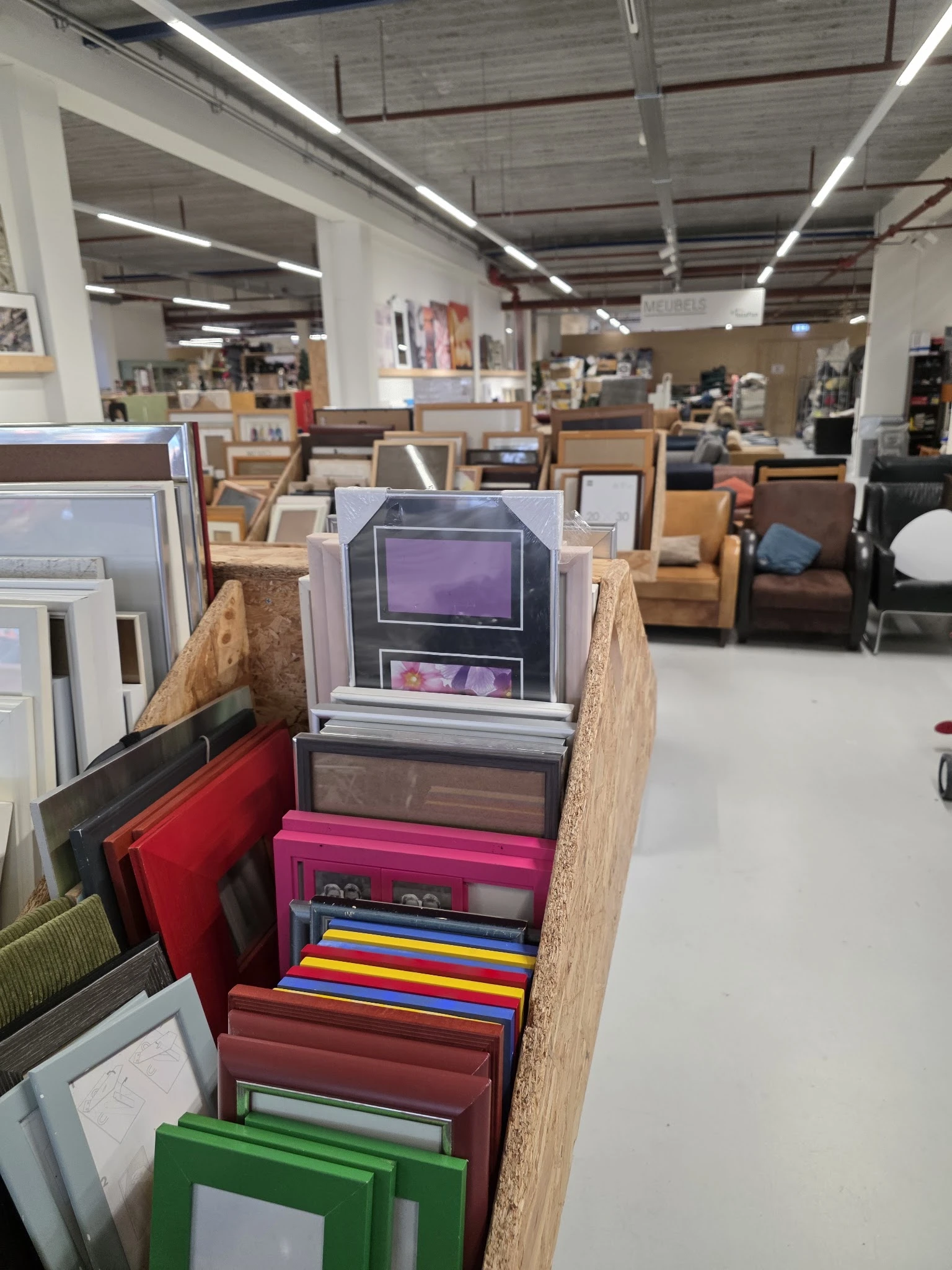 Verzameling vintage elektronische apparaten en andere tweedehands spullen op houten stellingen in de winkel