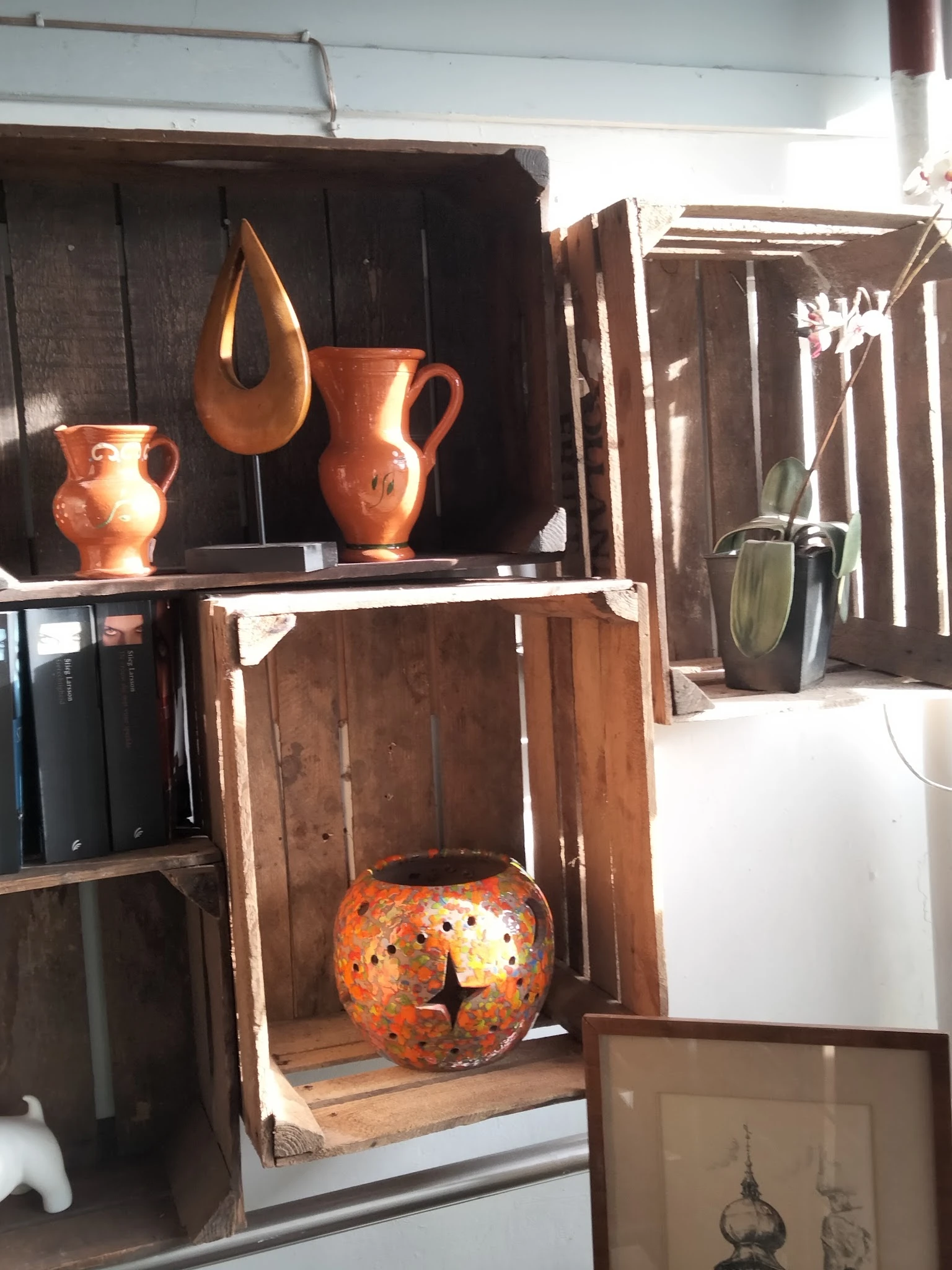 Uitgestalde vintage koperen kannen en keramische potten op houten kastjes en planken