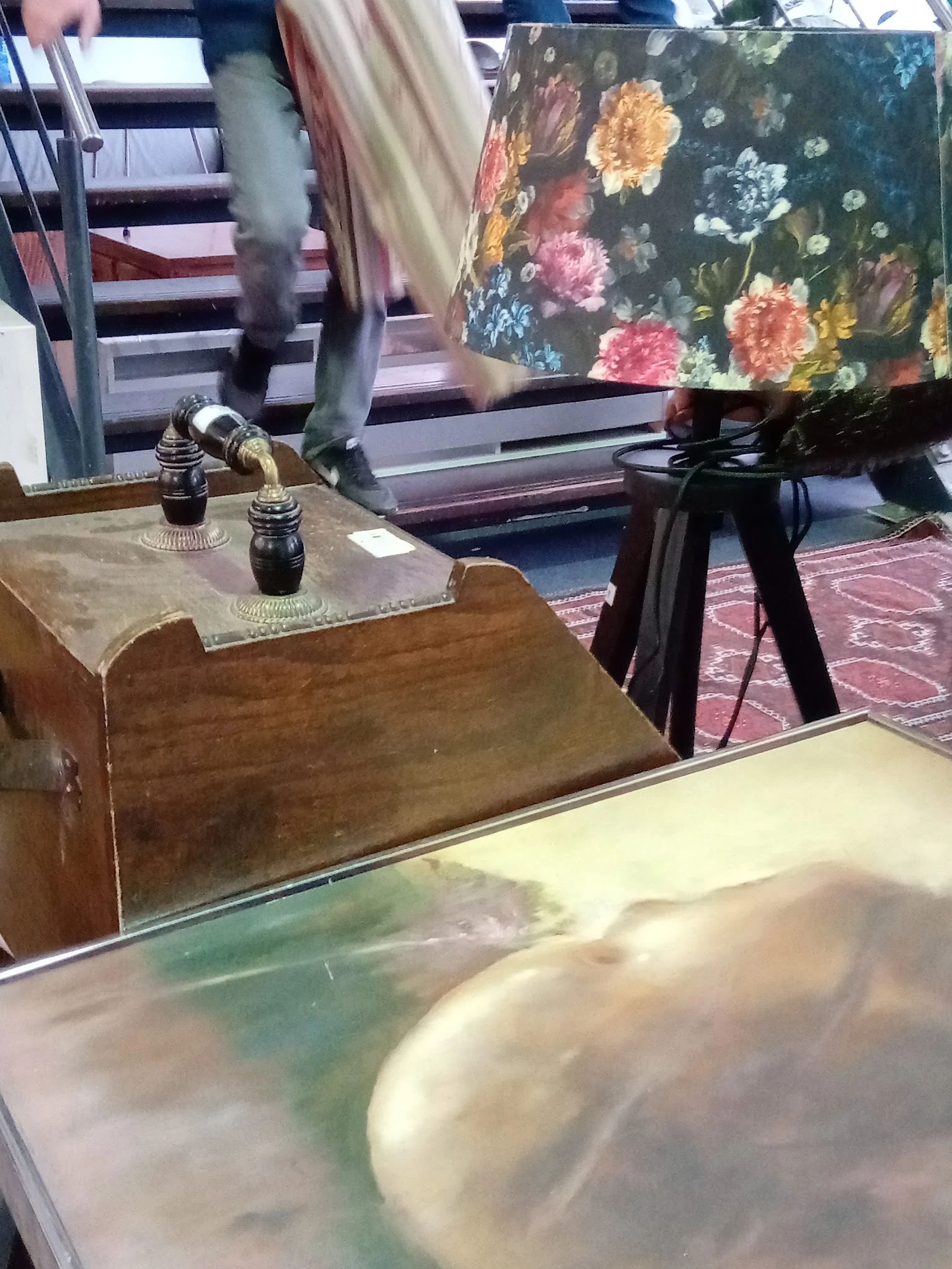 Winkelinterieur met houten meubels, vitrinekast en bloemenprint op muur