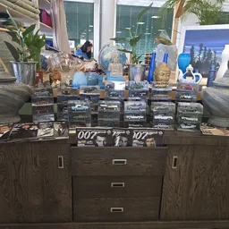 Verzameling miniatuurauto's en James Bond merchandise op een donkere kast met decoratieve elementen