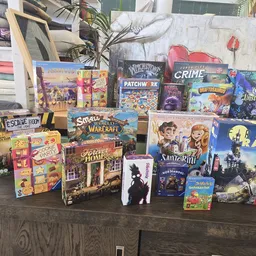 Tafel met uitgestalde bordspellen, kaartspellen en andere speelgoed in een kringloopwinkel