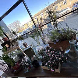 Raam met plantenpotjes, bloemen in vazen en decoratieve items op de vensterbank