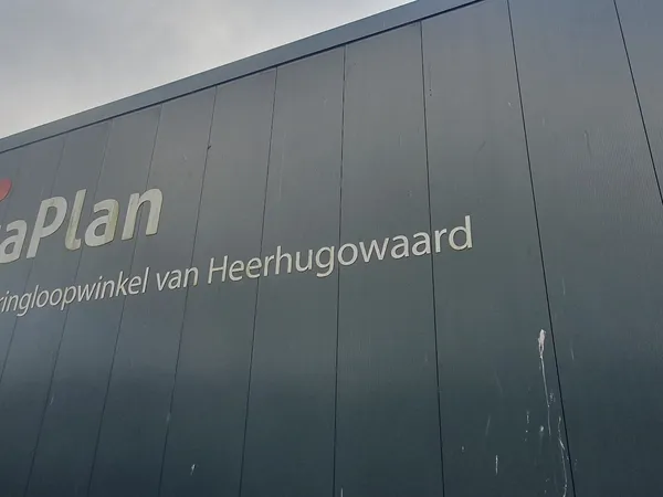 Grijze gevel van kringloopwinkel RataPlan Heerhugowaard met winkelnaambord