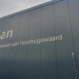 Grijze gevel van kringloopwinkel RataPlan Heerhugowaard met winkelnaambord