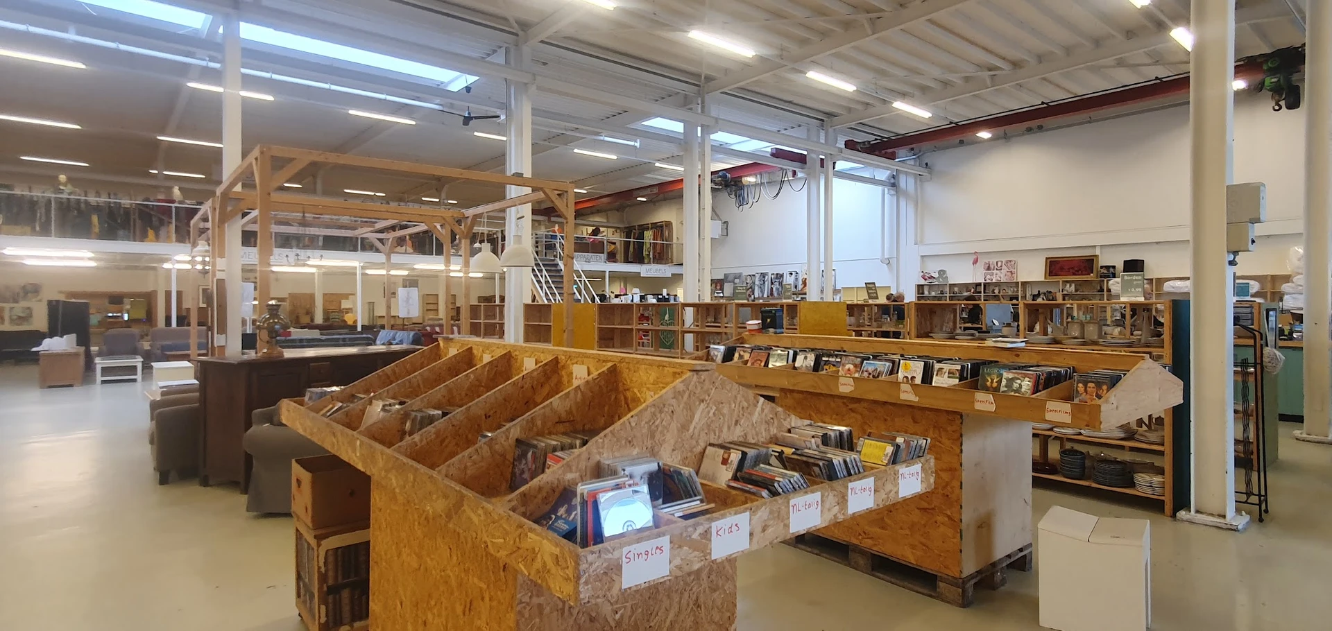 Winkelvloer met houten boekenkasten en uitgestalde boeken in vakken, modern winkelinterieur met kolommen en verlichting