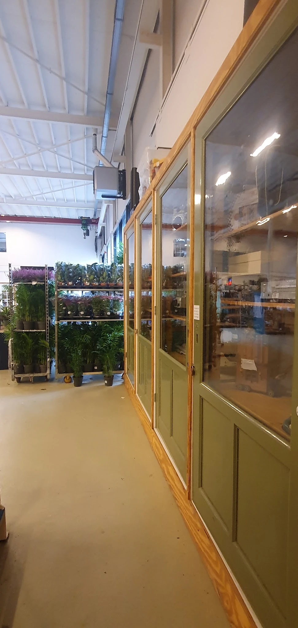 Winkelbinnenruimte met glazen deuren en plantjes op display tegen de linkermuur