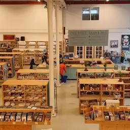 Winkelvloer van kringloopwinkel met houten stellingen vol tweedehands spullen en decoratieve items