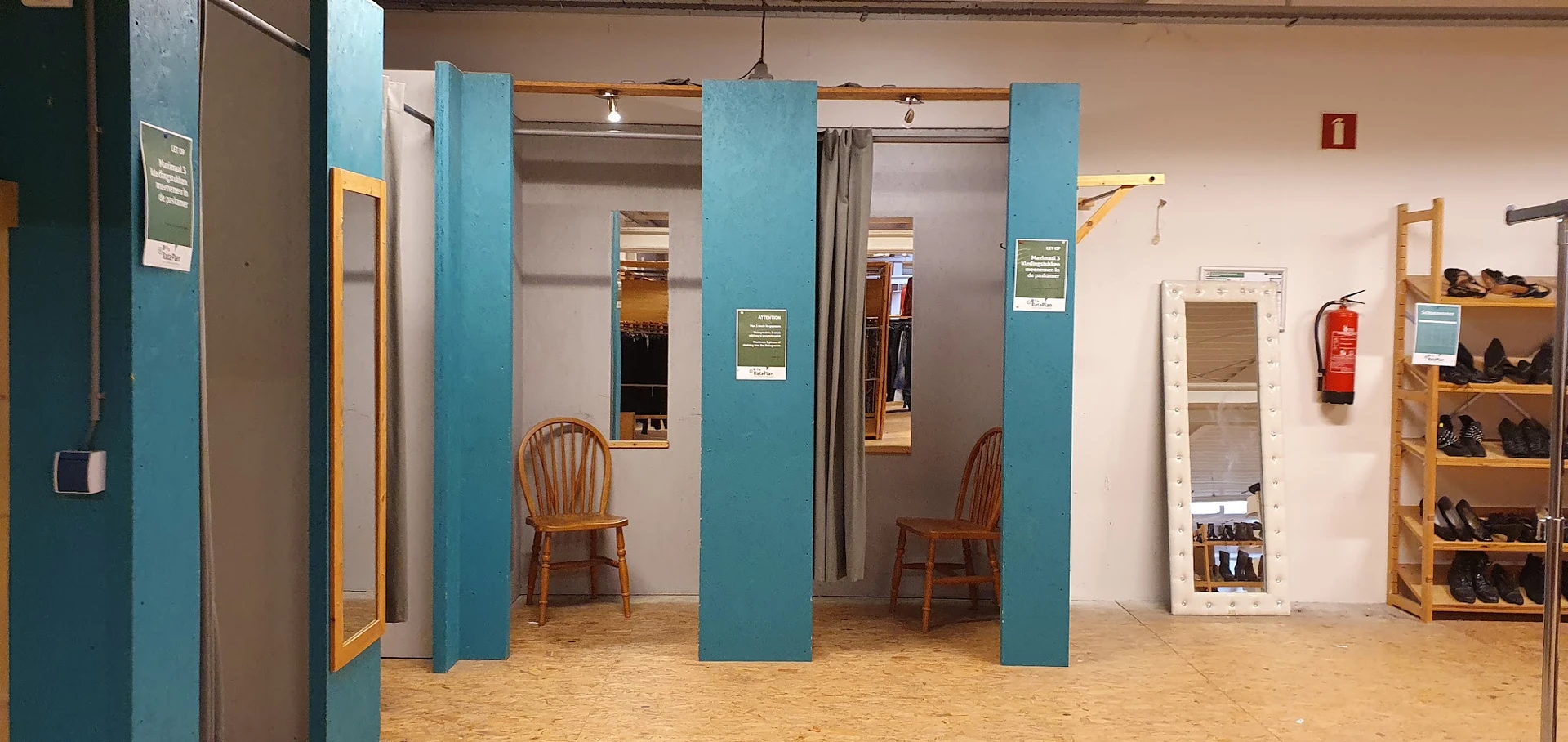 Winkelinterieur met blauwe kolommen, houten stoelen, spiegels en gordijnen