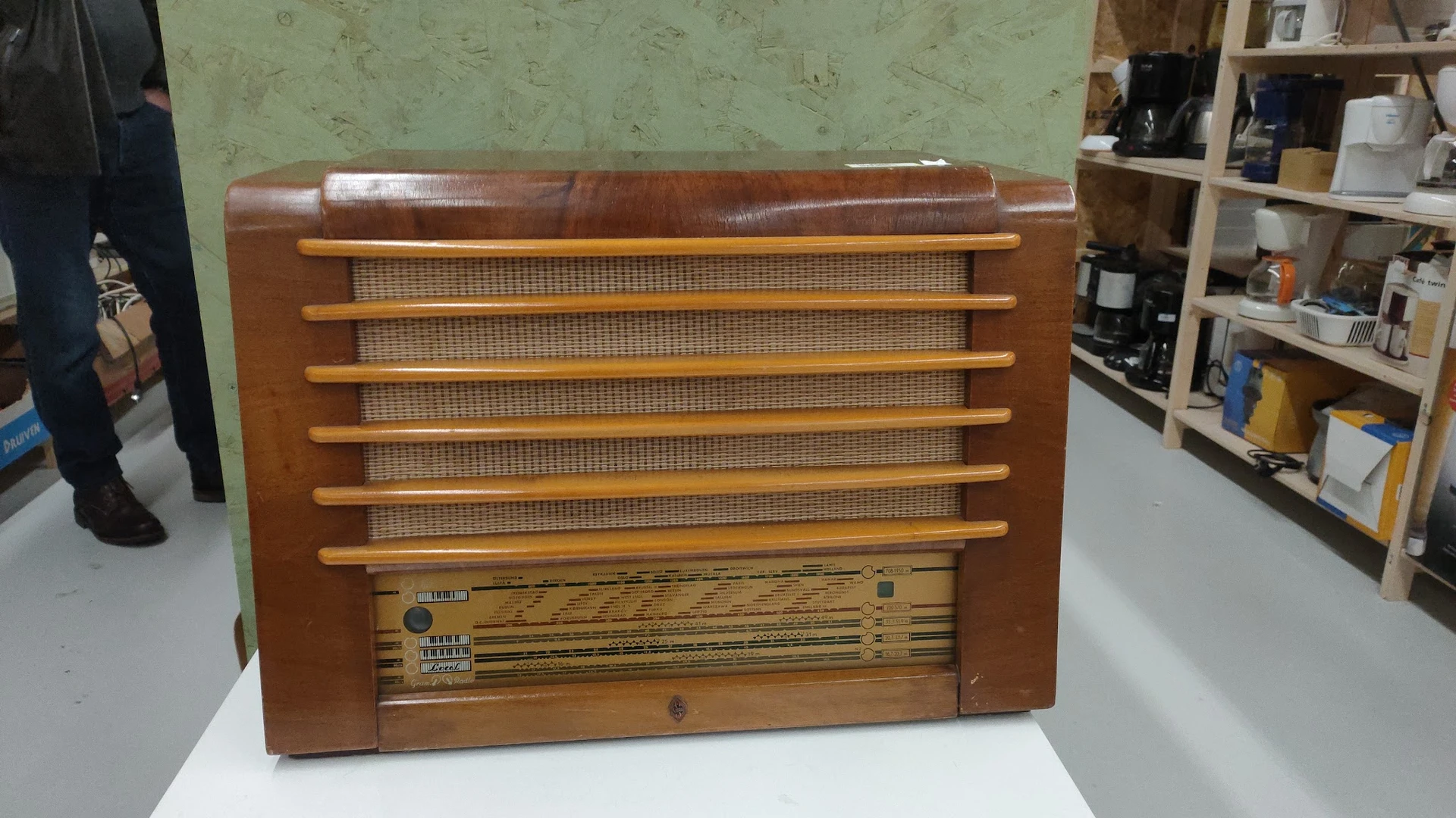 Houten vintage radio met bruin leren bovenkant en houten lamellen op de voorkant