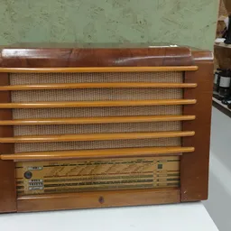Houten vintage radio met bruin leren bovenkant en houten lamellen op de voorkant
