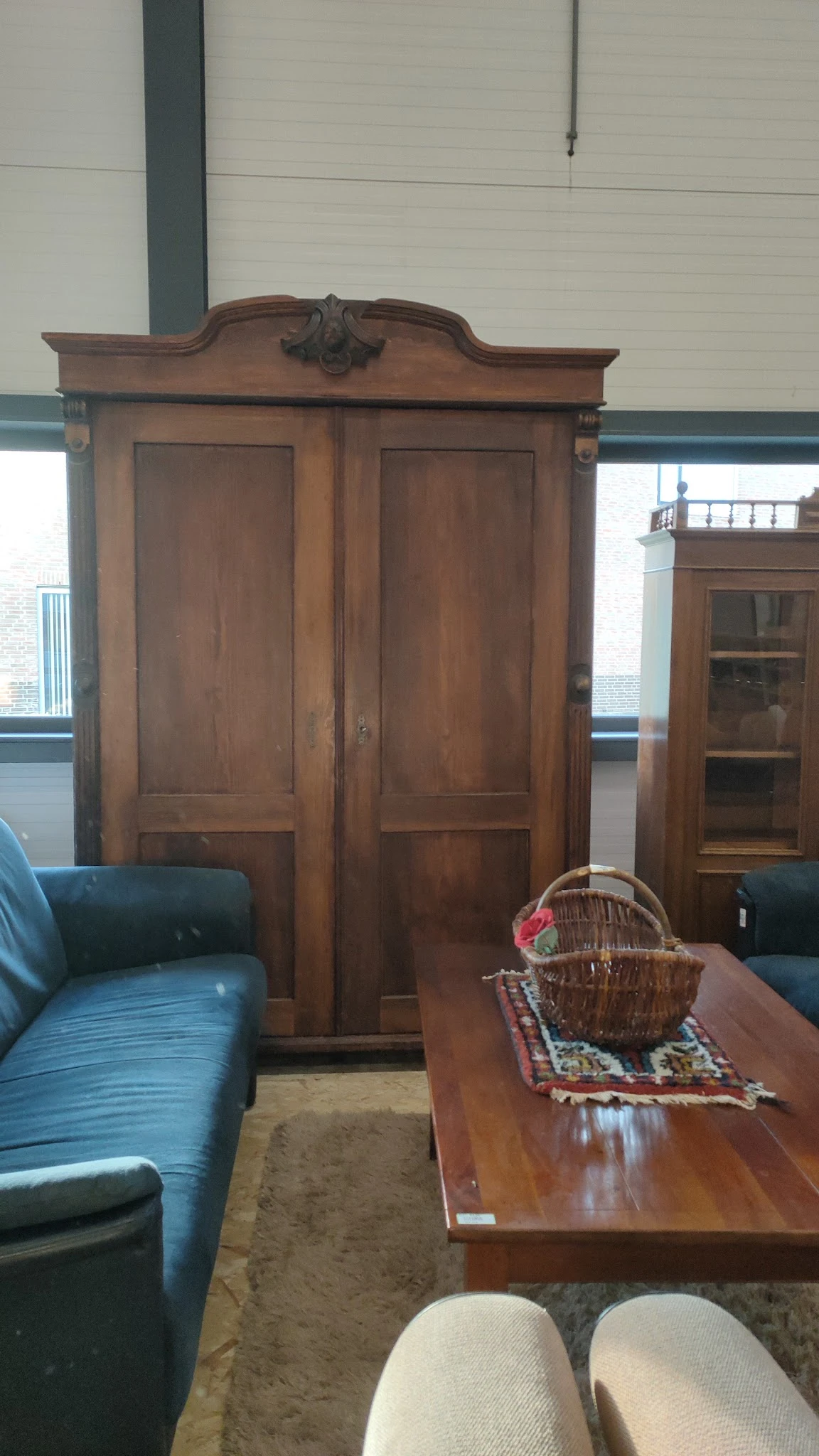 Winkelbinnenruimte met houten deuren, groene stoelen en stellingen met spullen