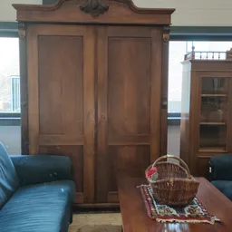 Winkelbinnenruimte met houten deuren, groene stoelen en stellingen met spullen