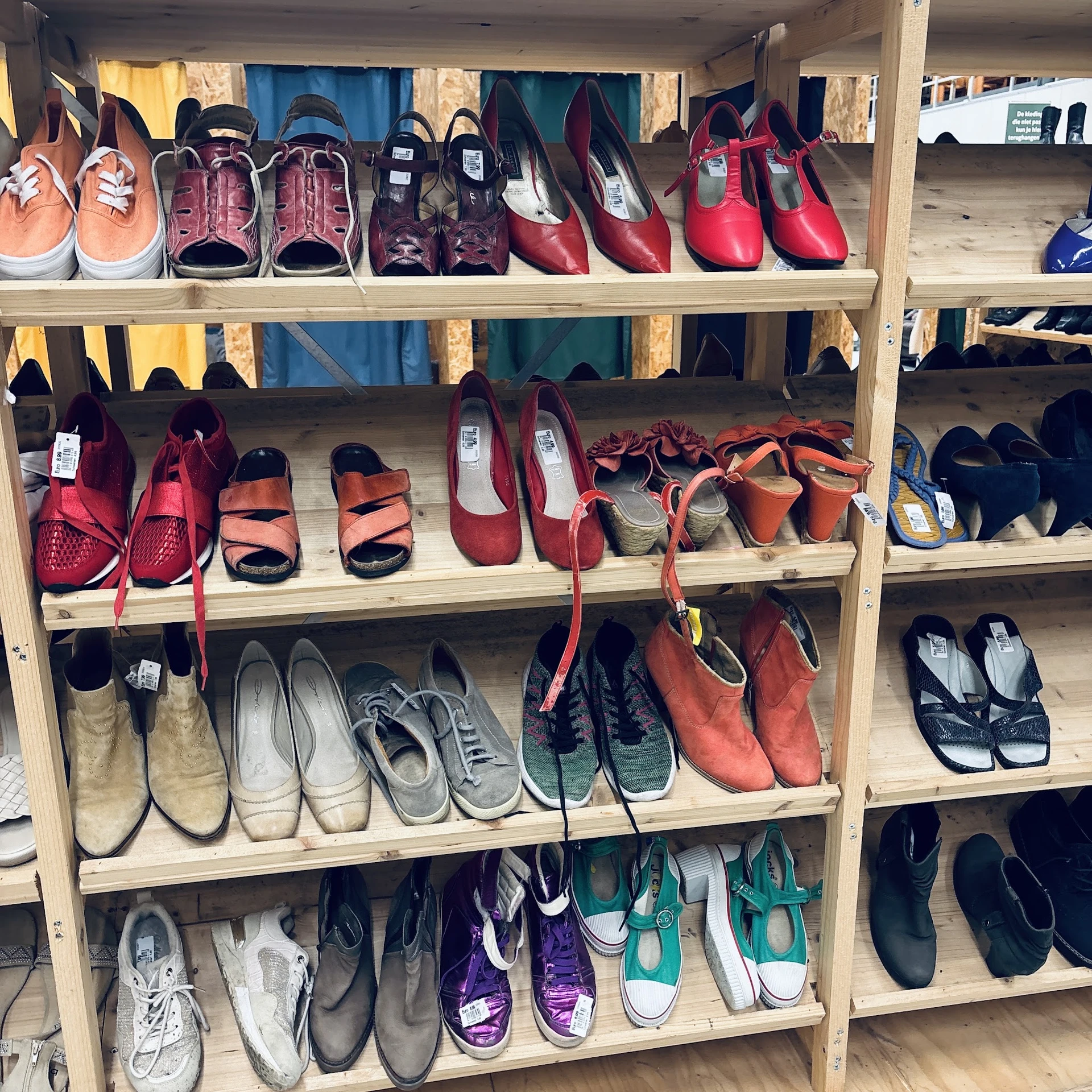 Houten stellingen met uitgestalde schoenen in verschillende kleuren en stijlen